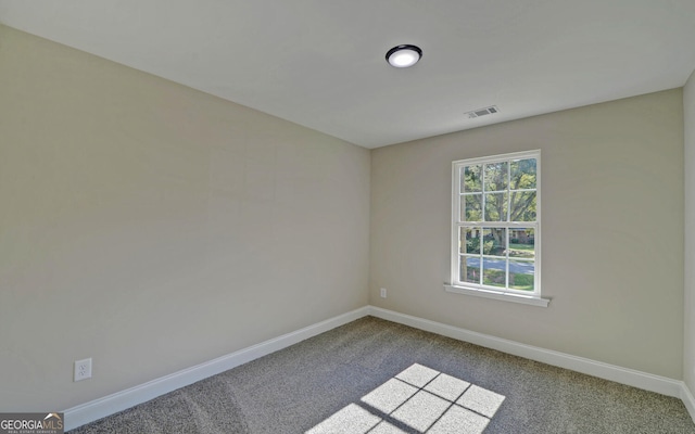 carpeted spare room featuring visible vents and baseboards