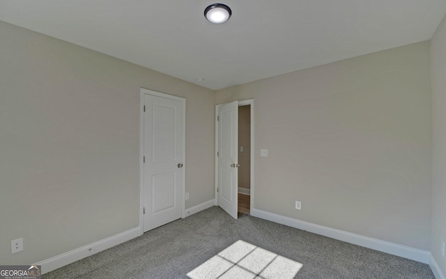 spare room featuring baseboards and carpet