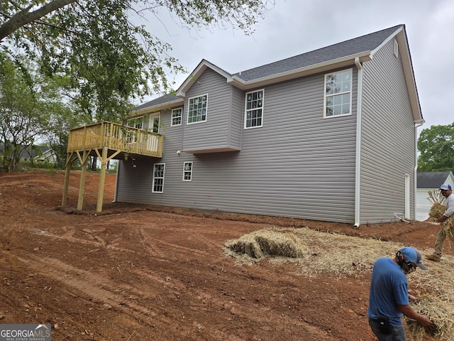 rear view of property featuring a wooden deck