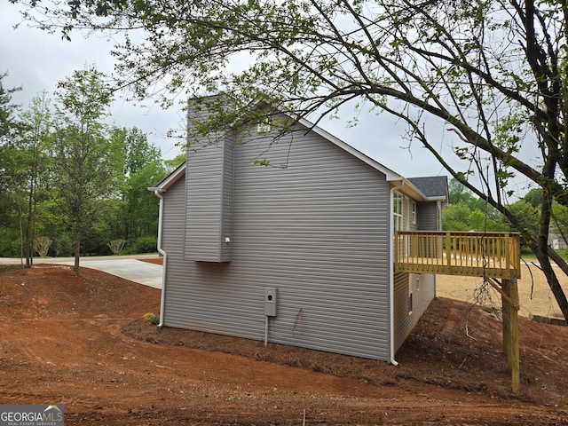 view of home's exterior featuring a chimney and a deck