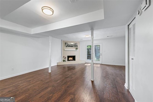 unfurnished living room with baseboards, hardwood / wood-style flooring, and a fireplace
