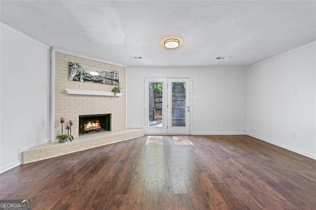 unfurnished living room with crown molding, visible vents, baseboards, and wood finished floors