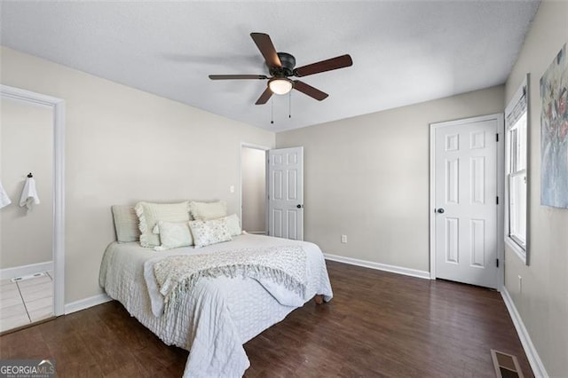 bedroom with visible vents, baseboards, a ceiling fan, and wood finished floors