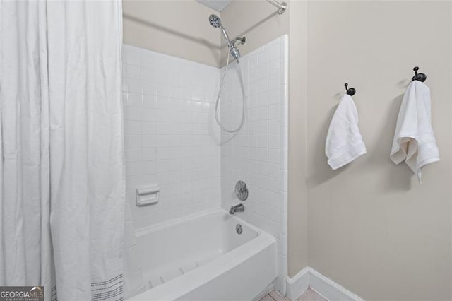 full bath with shower / tub combo with curtain and baseboards