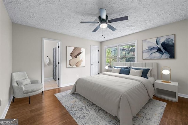 bedroom featuring baseboards, a textured ceiling, a ceiling fan, and wood finished floors
