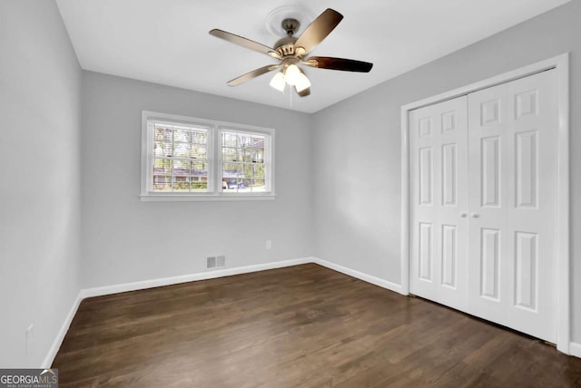 1093 Lanier Dr SW, Marietta, GA 30060 - unfurnished bedroom featuring a closet, baseboards, dark wood-style floors, and visible vents