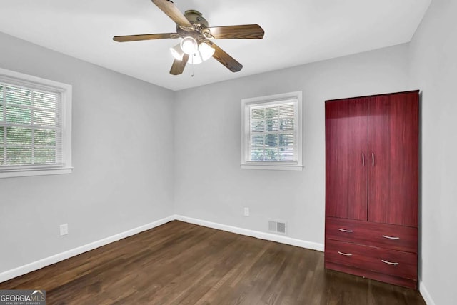 1093 Lanier Dr SW, Marietta, GA 30060 - unfurnished bedroom featuring dark wood-type flooring, baseboards, a ceiling fan, and visible vents