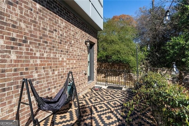 exterior space featuring brick siding and fence