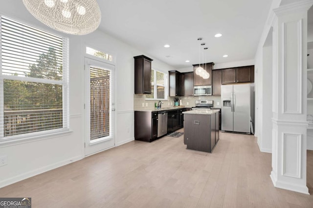 kitchen featuring decorative columns, dark brown cabinetry, and stainless steel appliances