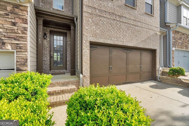 property entrance featuring brick siding and concrete driveway