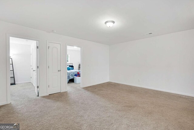 empty room featuring carpet flooring and baseboards