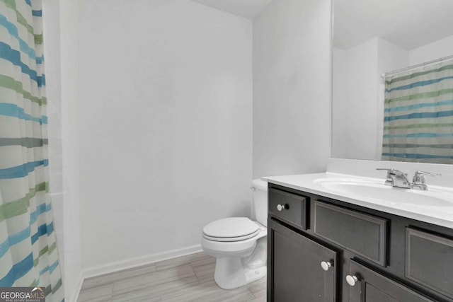 full bath with toilet, a shower with curtain, vanity, and baseboards