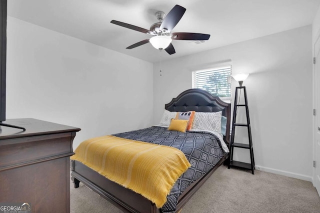 bedroom featuring light colored carpet, baseboards, and a ceiling fan