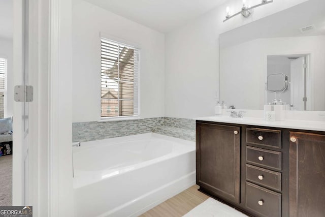 full bathroom featuring double vanity and a garden tub
