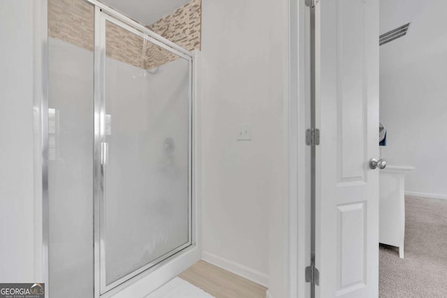 bathroom featuring baseboards and a shower stall