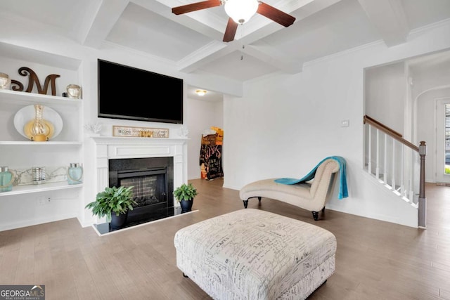living area featuring a ceiling fan, stairs, beam ceiling, coffered ceiling, and wood finished floors