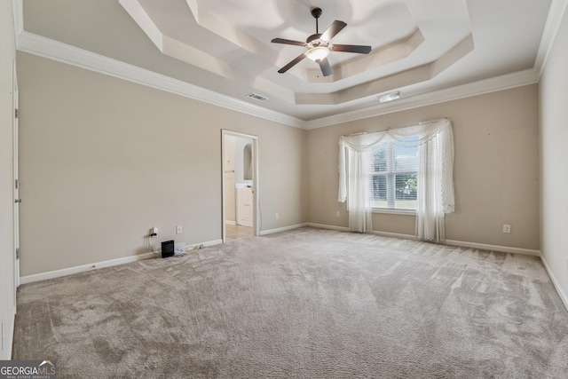 unfurnished room with a raised ceiling, a ceiling fan, carpet, crown molding, and baseboards