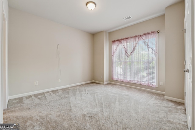 empty room featuring baseboards and carpet flooring