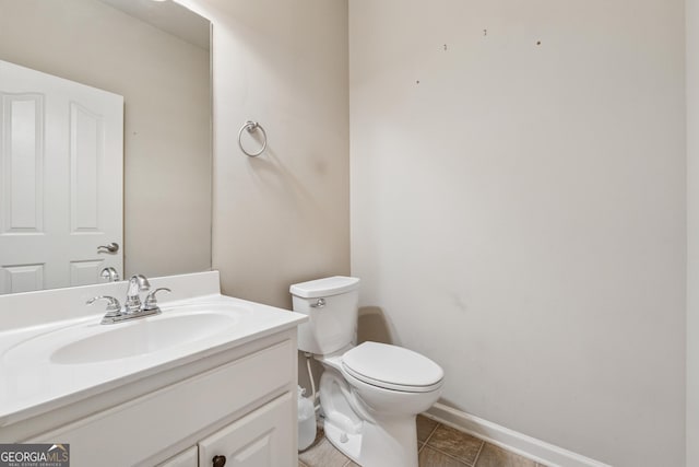 bathroom featuring baseboards, toilet, vanity, and tile patterned flooring