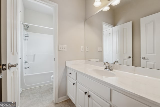 full bath featuring vanity, bathtub / shower combination, toilet, and baseboards