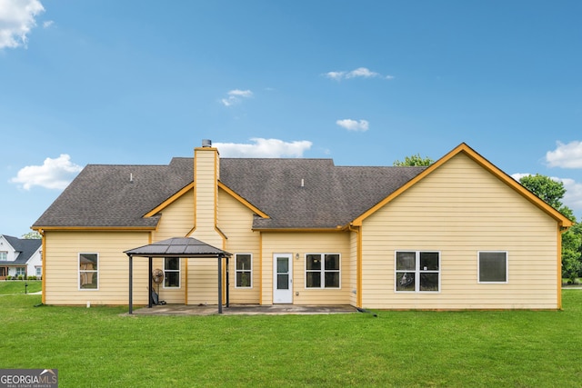rear view of house featuring a gazebo, a patio area, a yard, and a chimney