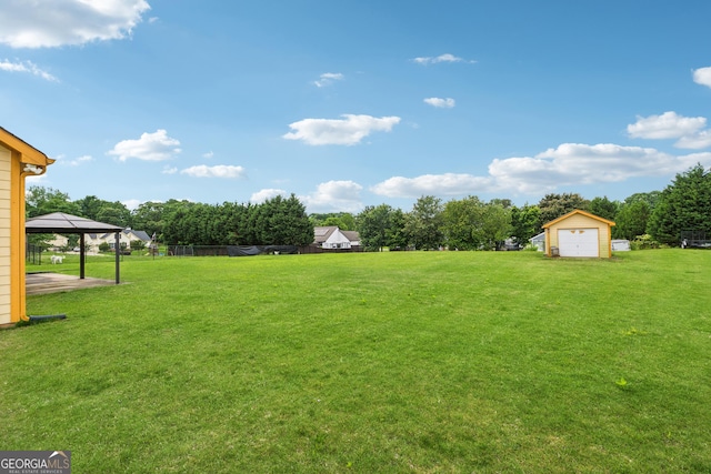 view of grassy yard with a gazebo, a shed, an outdoor structure, and a detached garage