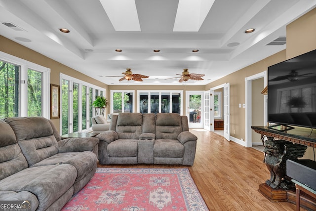 living area featuring recessed lighting, visible vents, a skylight, and wood finished floors