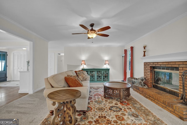 carpeted living room with baseboards, a ceiling fan, and ornamental molding