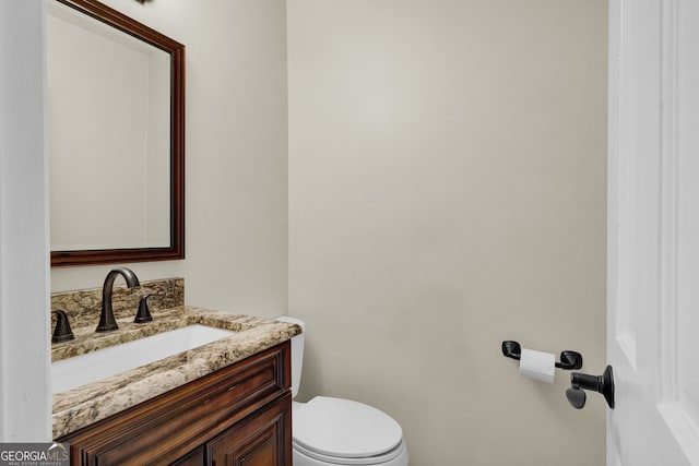 half bathroom with toilet and vanity