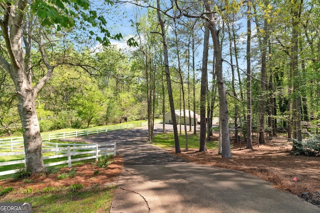 view of community with a forest view and fence
