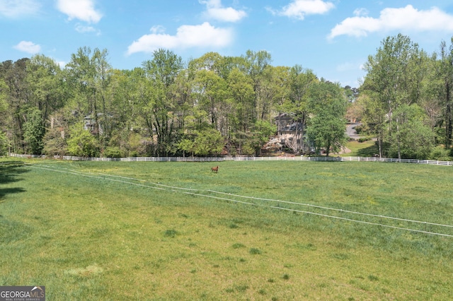 view of yard with a rural view and fence