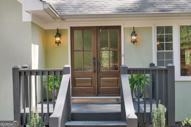 doorway to property with roof with shingles, french doors, and stucco siding