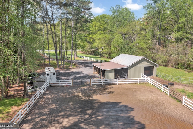 exterior space featuring an outbuilding, a wooded view, and an exterior structure