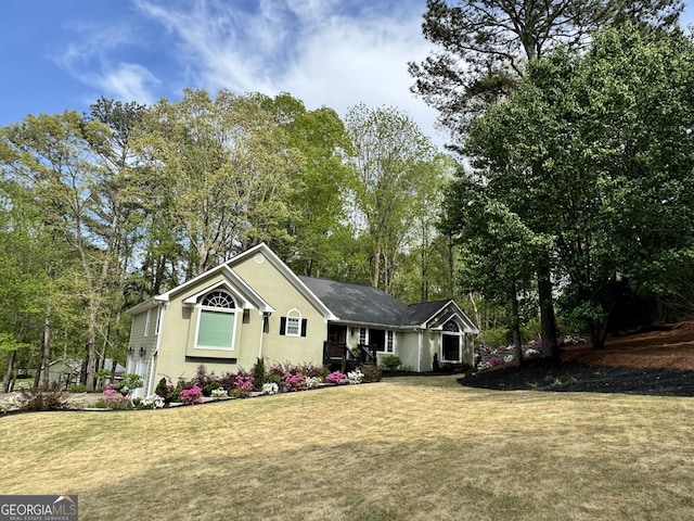 ranch-style home with a front yard and stucco siding