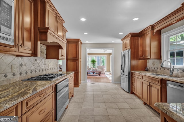 kitchen with recessed lighting, stone countertops, light tile patterned flooring, a sink, and stainless steel appliances