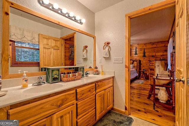 full bath featuring a sink, tile patterned floors, double vanity, and connected bathroom