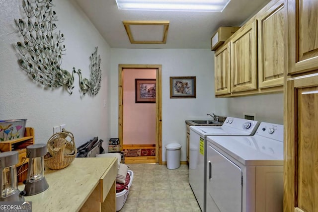 washroom with cabinet space, washing machine and clothes dryer, attic access, and a sink