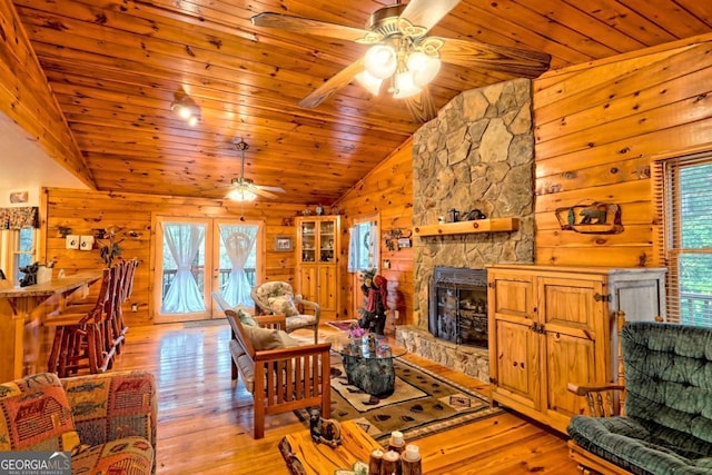 living area featuring ceiling fan, a wealth of natural light, vaulted ceiling, and wood ceiling