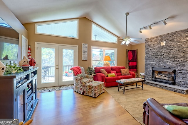 2537 Hunter Rd, Hiawassee, GA 30546 - living area with rail lighting, vaulted ceiling, a stone fireplace, wood finished floors, and french doors