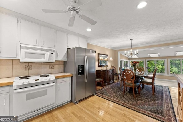kitchen featuring white appliances, light countertops, ornamental molding, and light wood finished floors