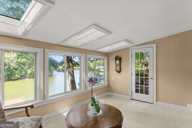 sunroom featuring a water view and a skylight