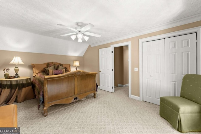 carpeted bedroom featuring ceiling fan, a textured ceiling, a closet, ornamental molding, and baseboards