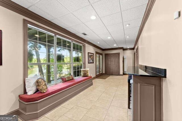hall with baseboards, recessed lighting, light tile patterned floors, crown molding, and visible vents