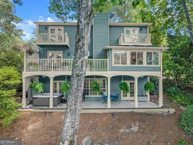 back of house featuring a patio, a balcony, french doors, and a hot tub