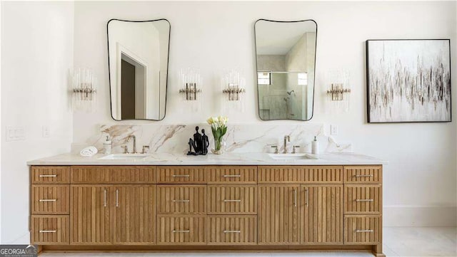 full bathroom featuring a shower stall, double vanity, a sink, and baseboards