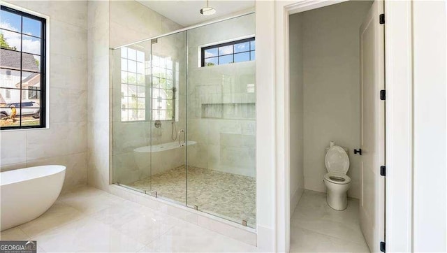 full bathroom featuring toilet, a stall shower, plenty of natural light, and a freestanding bath