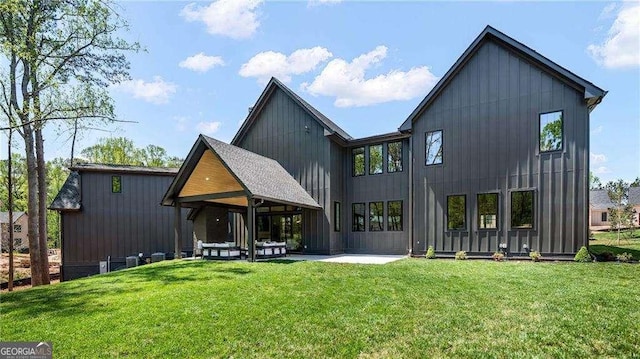 back of house with a yard, a patio area, and board and batten siding