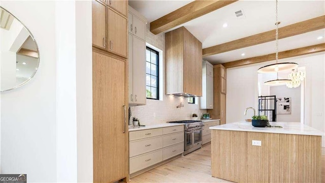 kitchen featuring beamed ceiling, light wood-type flooring, custom exhaust hood, high end stainless steel range oven, and decorative backsplash