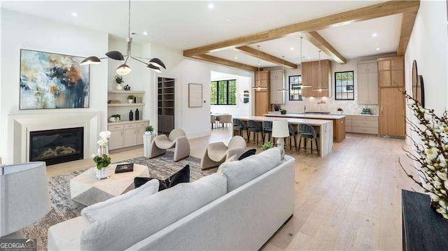 living room featuring a wealth of natural light, recessed lighting, a glass covered fireplace, and light wood-style flooring