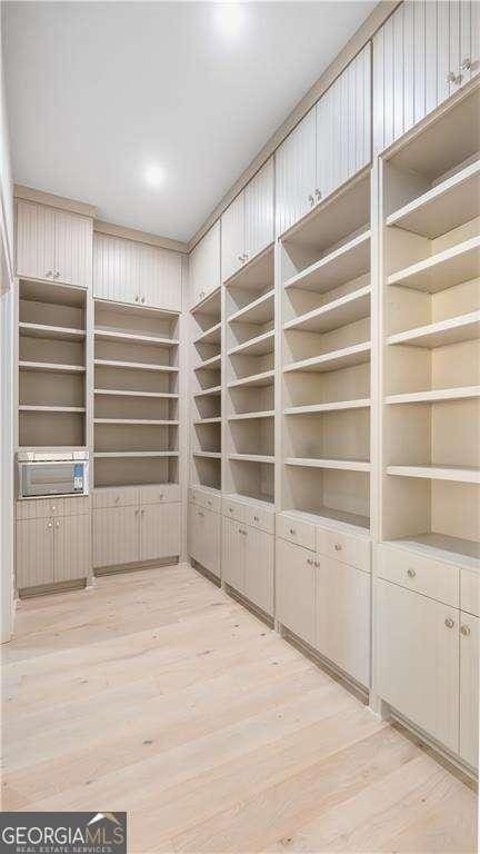 spare room featuring light wood-type flooring and built in features